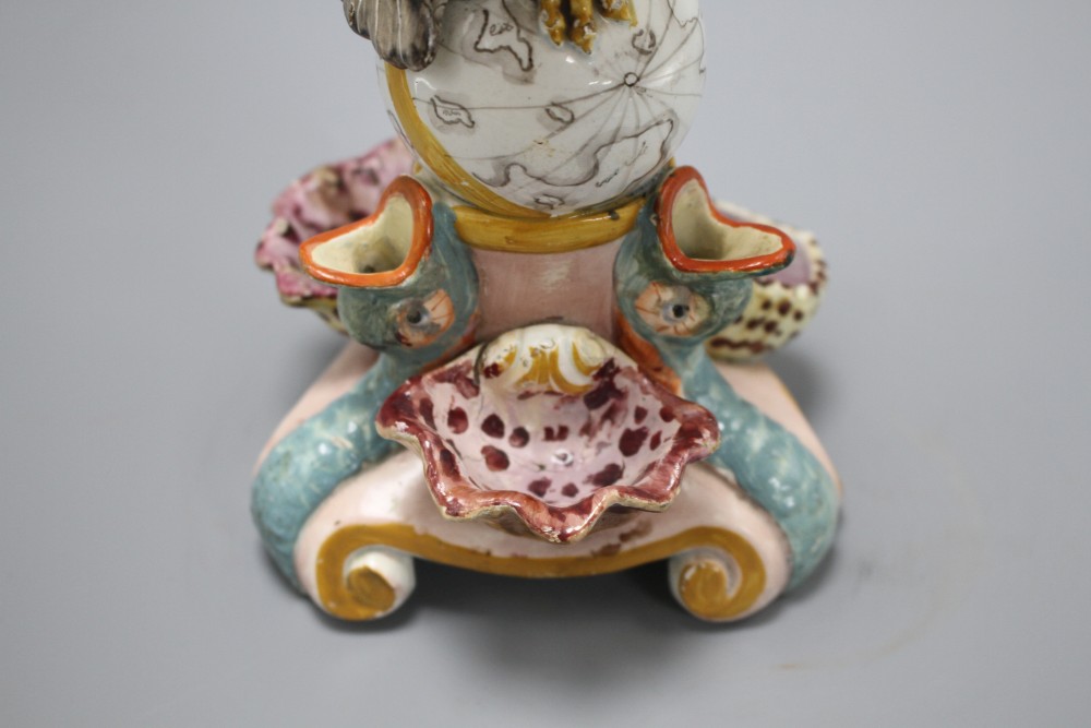 An early 19th century Staffordshire inkwell, modelled with an eagle perched upon a globe above three dolphins and shells, height 15cm